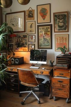 a desk with a computer on top of it next to a potted plant and pictures