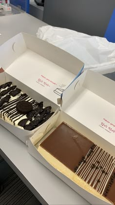 an open box with two different types of desserts in it on a counter top