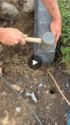 a man is using a hammer to dig in the ground