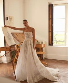 a woman standing in front of an easel