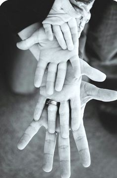 black and white photograph of multiple hands holding each other