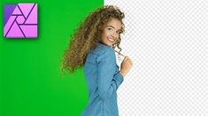 a woman with curly hair standing in front of a green and purple wall, smiling