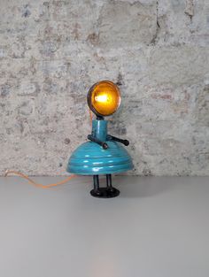 a blue table lamp with a yellow light on it