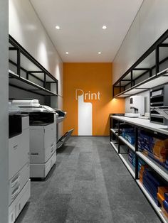 an office with rows of shelves and printer machines