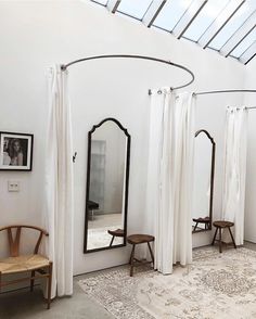 an instagram photo of mirrors and chairs in a room with white drapes on the walls