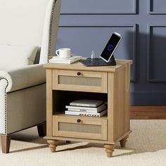 a laptop computer sitting on top of a wooden table next to a white chair in a living room