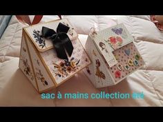 two small boxes with bows on them sitting on a bed