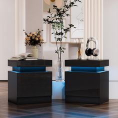 two black and blue side tables with flowers in vases next to eachother