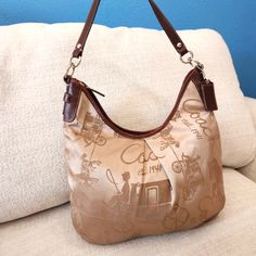 C56 14x10 Coach F14480 Horse & Carriage Signature Sateen Leather Hobo Shoulder Bag Production Date Is October 2009 Add A Touch O F Sophisication To Your Wardrobe With This Coach Shoulder Bag. The Bag Is Tan And Brown Imprinted With Coach Horse And Buggy With A Single Strap Which Has A Strap Drop Of Eleven Inches And Brown Leather Trim And Strap. The High -Quality Crafted Leather And Sateen Finish Makes It A Bag Perfect For Accessory For Business, Travel , Casual And Evening Wear. The Bag Has Sil Coach Hobo Bag With Dust Bag, Coach Beige Hobo Bag For Travel, Horse And Buggy, Horse Carriage, Hobo Shoulder Bag, Coach Shoulder Bag, Large Shoulder Bags, Leather Hobo, Business Travel