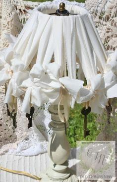 a white lamp shade sitting on top of a table next to a crochet doily