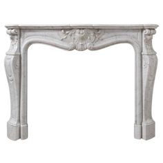 a white marble fireplace mantel with an ornate design on the top and bottom part