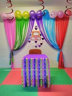 a party room with balloons and streamers on the ceiling, table set up for an event