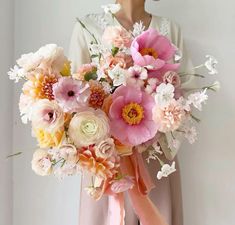 a woman holding a bouquet of flowers in her hands