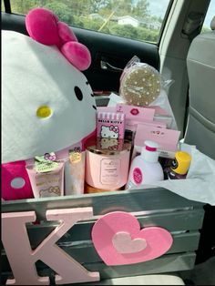 hello kitty in the back seat of a car filled with personal care products and gifts