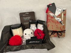 the contents of a gift bag are laid out on top of a bed with a notepad, coffee cup and other items