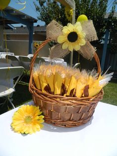 a basket filled with yellow flowers sitting on top of a table next to a sunflower