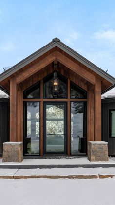 the front entrance to a building with large glass doors and stone pillars on each side