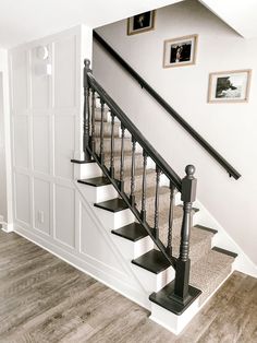 there is a staircase in the house with pictures on the wall and carpeted floor