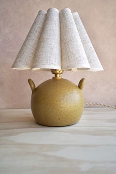 a table lamp that is sitting on top of a table with a cloth shade over it