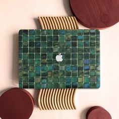 an apple logo is displayed on the back of a green and gold mosaic tile wall