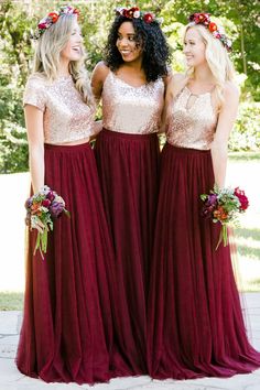 three bridesmaids in burgundy dresses with gold sequins and flower crowns on their heads