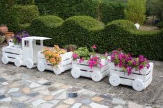 two white wooden carts with flowers in them