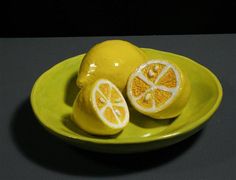 a yellow plate topped with sliced lemons on top of a table