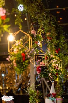 flowers and greenery are hanging from the ceiling