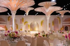 an elaborately decorated banquet hall with white chairs and tables set up for a formal function