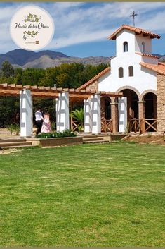 a man and woman are standing in front of a church with mountains in the background