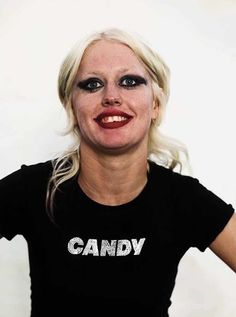 a woman with makeup on her face posing for a photo in front of a white background