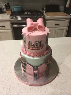 a three tiered cake with minnie mouse decorations on the front and side, sitting on top of a kitchen counter