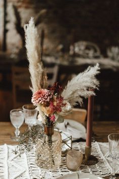 the table is set with flowers and candles