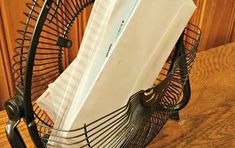 a close up of a metal object on a wooden table with books and papers sticking out of it