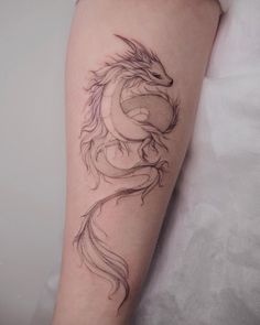 a woman's arm with a dragon tattoo on it