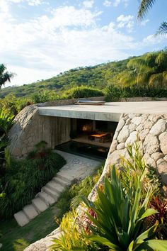 an open fire place in the middle of a lush green hillside