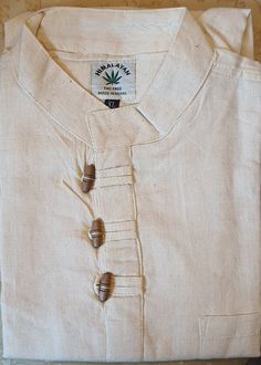 You are looking at full sleeve grandad Shirt/Kurta, with 3 hand carved wooden buttons  for casual, summer, festival,Yoga, beach use. Features:     ✔Colour: Cream/White    ✔Classic design    ✔Size Chart: Please look at 2nd picture    ✔Material:         1.Upto 40% Organic Hemp fibre         2.Upto 40% Sustainable Bamboo Fibre          3.Upto 20 % Cotton fibre    ✔3 Traditional handmade wooden buttons fitted    ✔High quality fabric    ✔High quality stitching 1.Hemp Fibre: Hemp fibre is sustainable fibre obtained from hemp plants mostly found in empty or barren lands in Asian countries.Normally, it grows without needing any care, water or pesticides. It helps to lower carbon footprints and also does not cause any damage to soil quality. 2.Bamboo Fibre: Speciality of Bamboo Fibre: ✔Very very so Hemp Fabric Clothing, Traditional Cotton Top With Stand Collar, Traditional Stand Collar Top With Buttons, Traditional Long Sleeve Shirt With Button Closure, Long Sleeve Summer Kurta With Buttons, Summer Long Sleeve Kurta With Buttons, Traditional Long Sleeve Summer Shirt, Relaxed Fit Long Sleeve Shirt For Festival, Casual Long Sleeve Beige Kurta