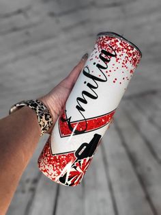 a hand holding a can of soda with red sprinkles on the side