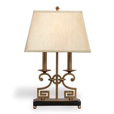 a table lamp with a white shade on it's side and a black base