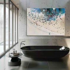 a bath tub sitting next to a large painting on the side of a wall in a bathroom