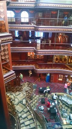 the inside of a building with many stairs and people walking up it's sides