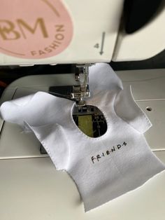 a close up of a sewing machine with a white shirt on it's side