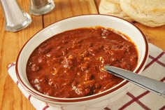 a white bowl filled with chili on top of a table