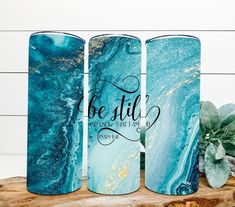 three blue marbled canisters with the words be still on them