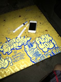 a cell phone sitting on top of a table covered in graffiti