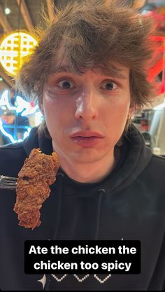 a young man holding a piece of fried chicken in his right hand and the words ate the chicken the chicken too spicy