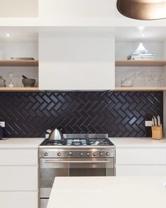 a stove top oven sitting inside of a kitchen next to a white counter tops and cabinets