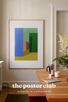 a painting hanging on the wall above a wooden table in a room with white walls