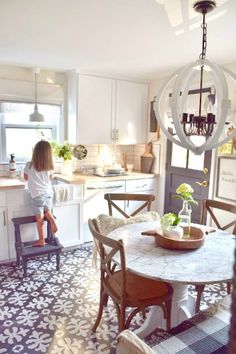 a woman sitting at a table in a kitchen