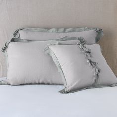 three pillows with ruffled edges on a bed